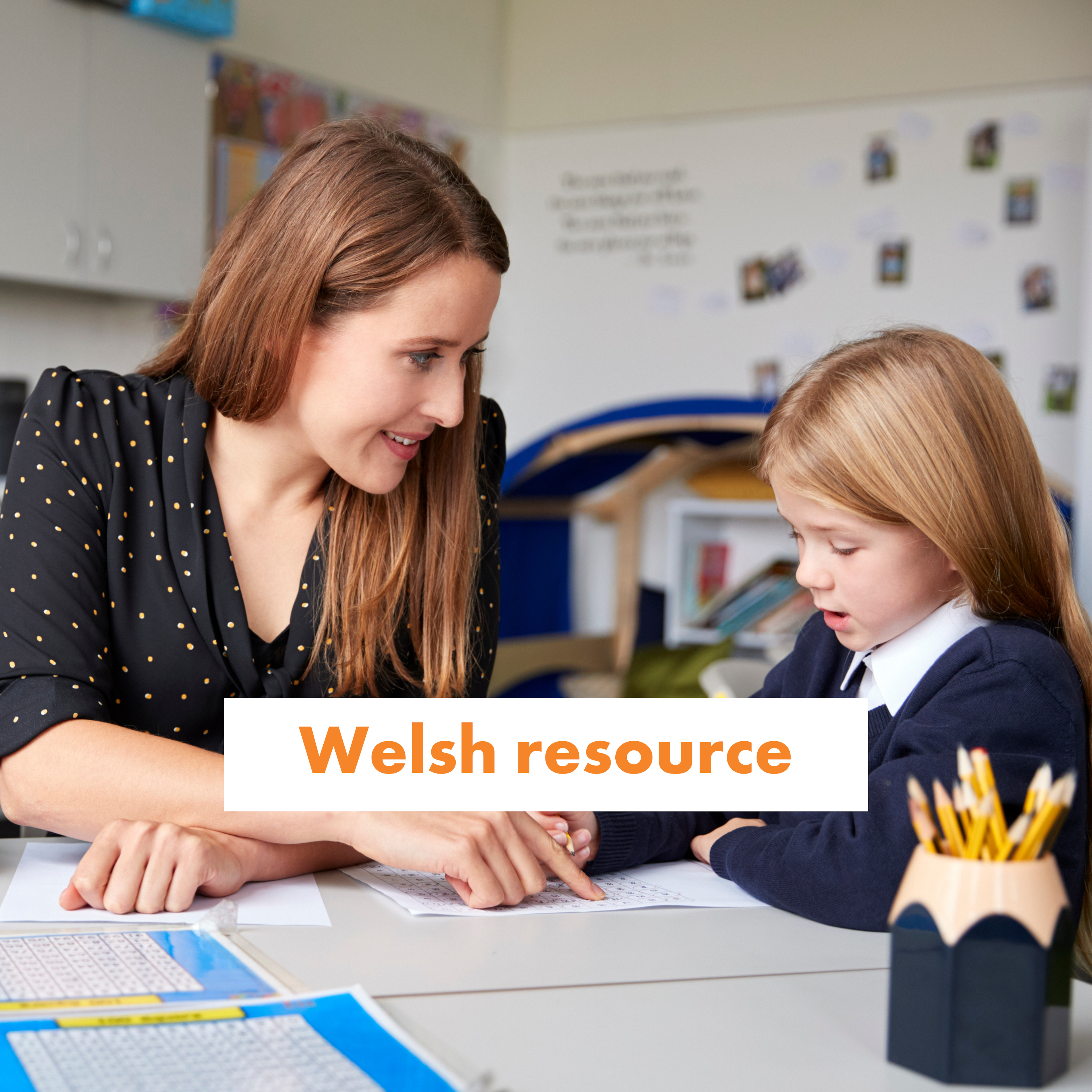 Teacher and child working on maths on paper.