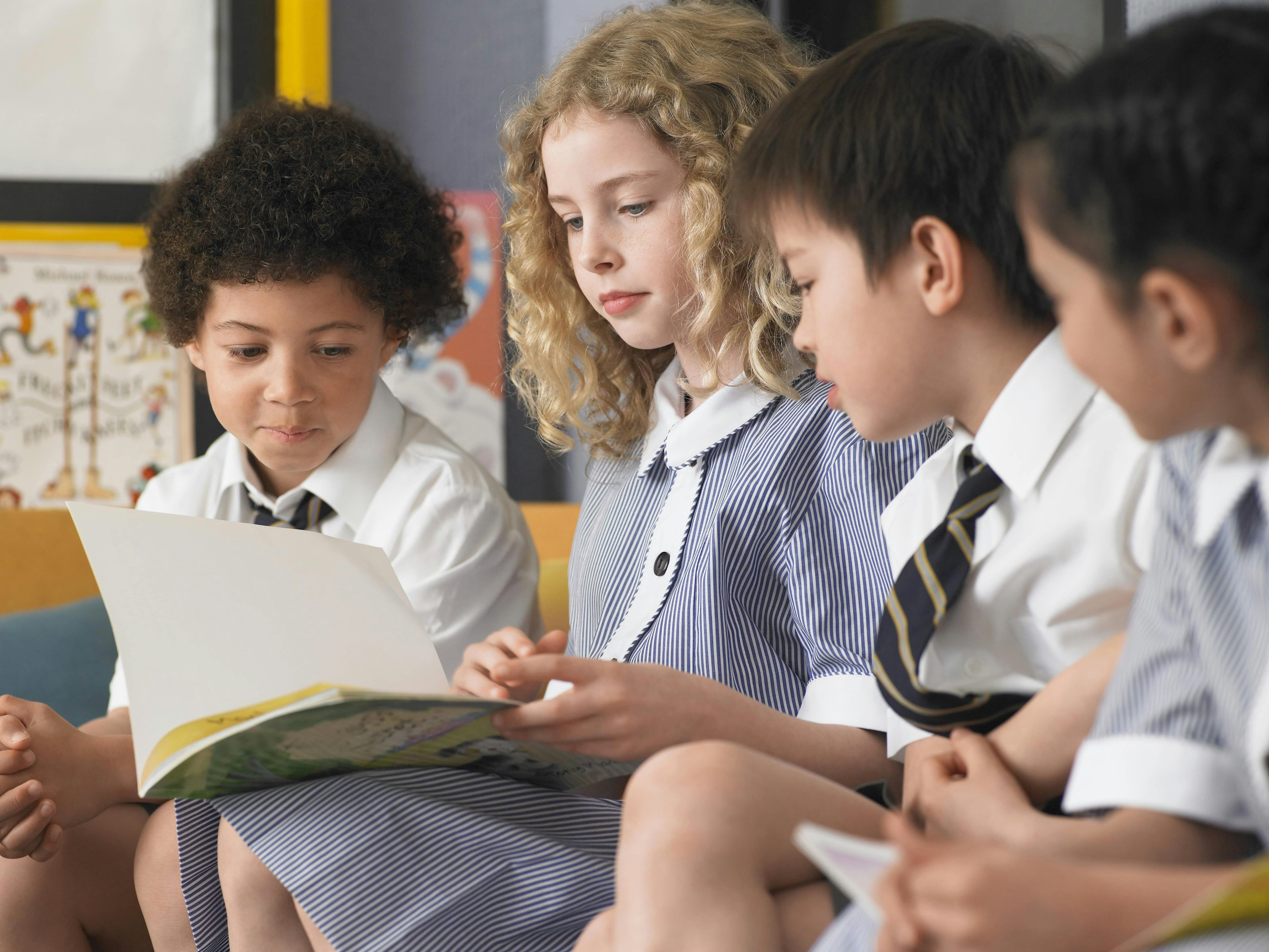 School children reading a book.